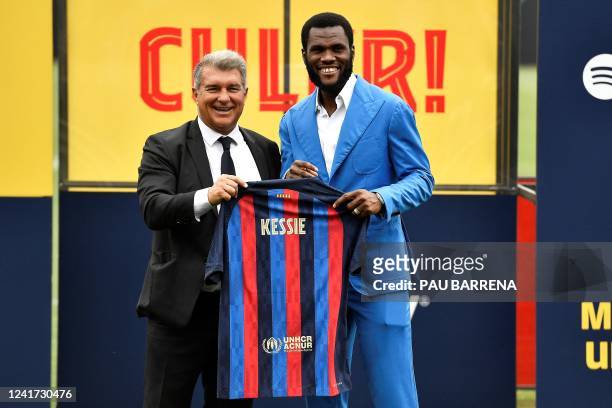 Barcelona's new Ivorian midfielder Franck Kessie poses for pictures with Barcelona's Spanish President Joan Laporta holding his new jersey during his...