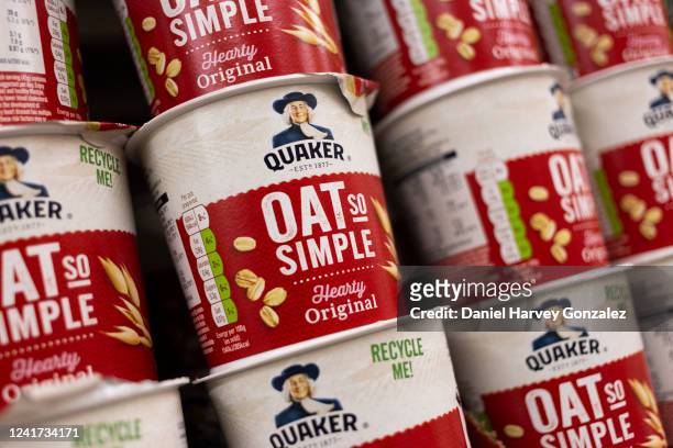Rows of original Oat So Simple pots by Quaker Oats, convenient recylcable pots of porridge oats, stacked on top of one another on a supermarket shelf...