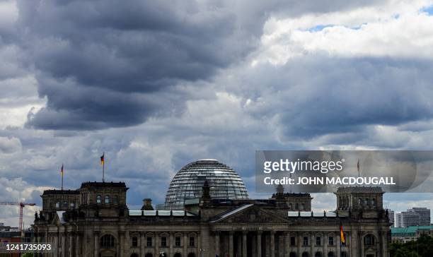 Photo taken from the Chancellery in Berlin, on July 6, 2022 shows clouds over the Reichstag building which houses Germany's lower house of parliament...