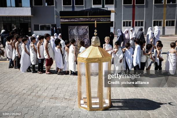 July 2022, Syria, Atmeh: Syrian children perform Hajj rituals around a model of the Kaaba, Islam's holiest shrine, and Maqam Ibrahim , during an...