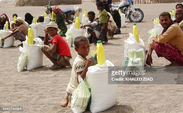 Yemenis displaced by the conflict, receive food aid and supplies to meet their basic needs, at a camp in Hays district in the war-ravaged western...