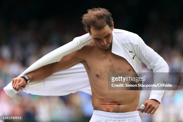 Rafael Nadal v Taylor Fritz - Rafael Nadal removes his shirt revealing the tape for his abdominal injury after his five set victory during day ten of...