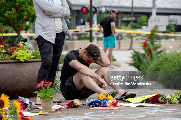 Mourners react at a memorial site for the victims of a mass shooting at a Fourth of July parade, on July 6, 2022 in Highland Park, Illinois....