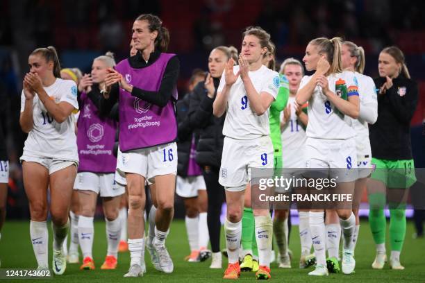 England's players celebrate on the pitch after the UEFA Women's Euro 2022 Group A football match between England and Austria at Old Trafford in...