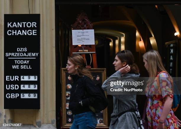 People walk past a sign outside an exchange office in Krakow's Old Town. On Wednesday, July 06 in Krakow, Poland.