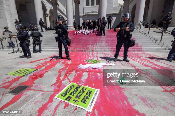 Police arrest four women protesters who chained themselves to the columns at the steps of City Hall to denounce the U.S. Supreme Court decision that...