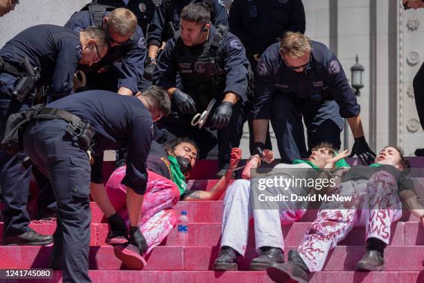 Police arrest four women protesters who chained themselves to the columns at the steps of City Hall to denounce the U.S. Supreme Court decision that...