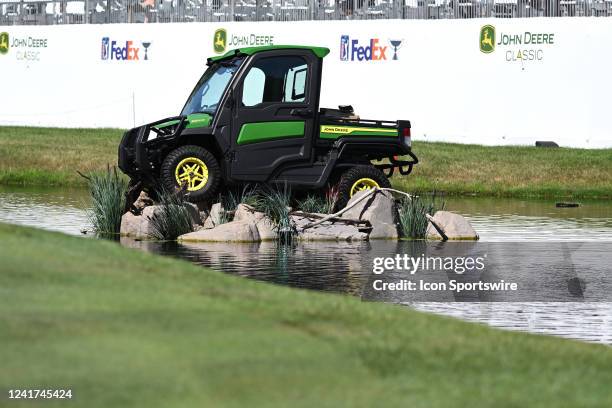 John Deere all terrain vehicle sits in the water hazard on the 18th hole during the final round of the John Deere Classic Golf Tournament on July 03...