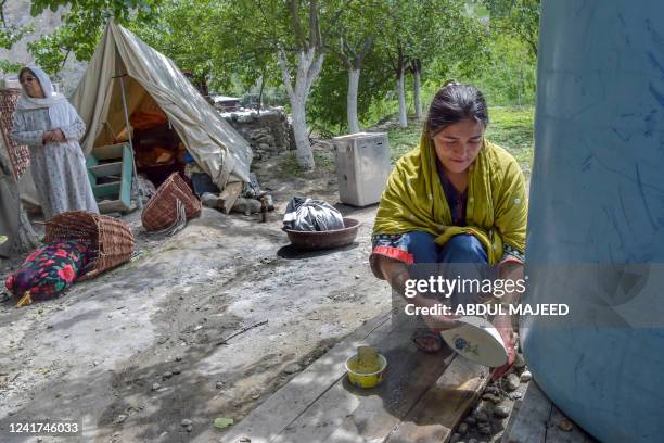 In this picture taken on June 9 a local resident washes dishes outside tents setup after their homes were swept by a lake outburst because of a...