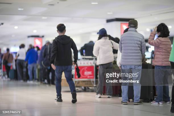 Passengers queue to enter the check-in areas for Qantas Airways Ltd. At Sydney Airport in Sydney, Australia, on Wednesday, July 6, 2022. Qantas,...