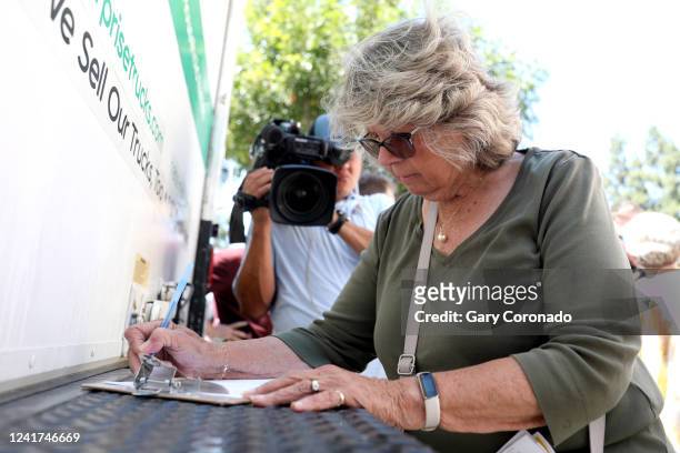 Linda Jane Bouffard, of Cerritos, signs a recall petition, after a truck arrives with over 700,000 petition signatures in an effort to recall Los...