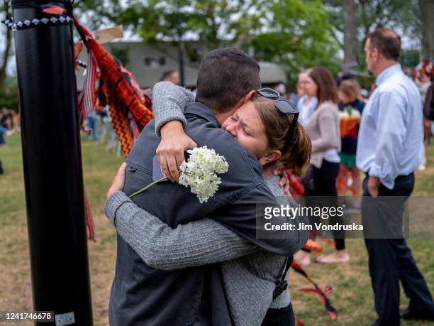 People embrace at a vigil in Everts Park for those killed near the scene of a shooting at a Fourth of July parade, on July 6, 2022 in Highwood,...