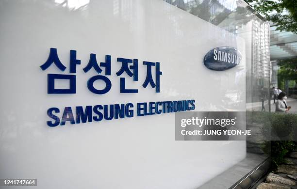 People walk past the logo of Samsung Electronics outside the company's Seocho building in Seoul on July 7, 2022.
