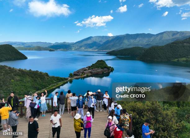 Aerial photo taken on July 7, 2022 shows tourists visiting Lige Island in Lugu Lake in Lijiang, Yunnan Province, China. Lugu Lake, known as the...