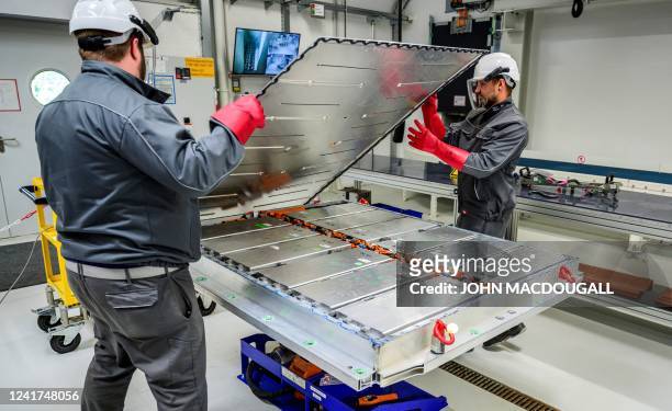 Workers open up a battery pack, revealing the battery modules, at Volkswagen's pilot recycling plant for car battery cells at the VW component plant...