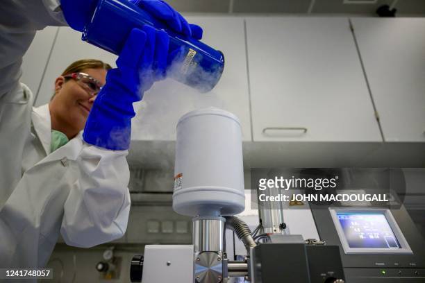 Technician poors liquid nitrogen into a "Cryo Cross Section Polisher" to prepare battery cell components to be viewed in the electron microscope at...