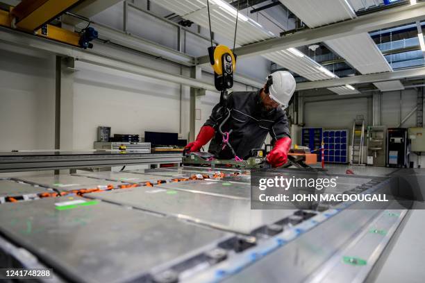 Worker removes a module, containing the battery cells, from a battery pack at Volkswagen's pilot recycling plant for car battery cells at the VW...