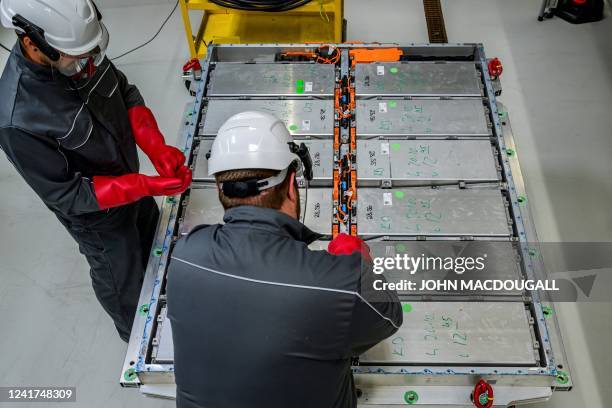 Workers prepare to take out modules, containing the battery cells, from a battery pack at Volkswagen's pilot recycling plant for car battery cells at...
