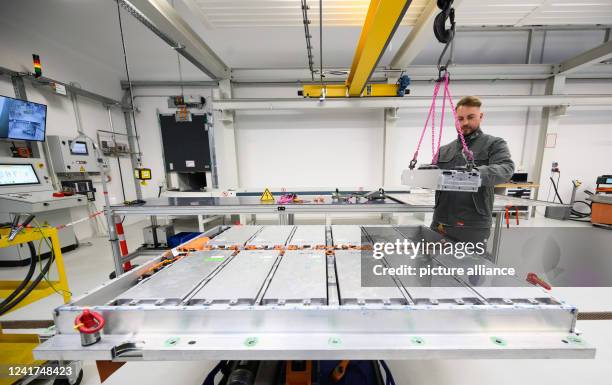 May 2022, Lower Saxony, Salzgitter: An employee removes a battery module from a worn-out battery of an electric car in battery recycling at the VW...