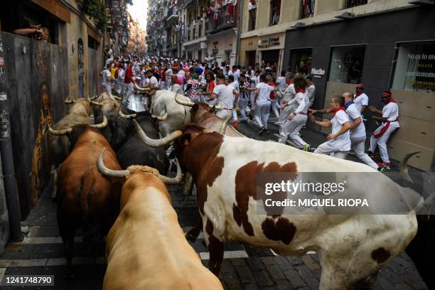 Participants run ahead of bulls during the "encierro" of the San Fermin festival in Pamplona, northern Spain on July 7, 2022. On each day of the...