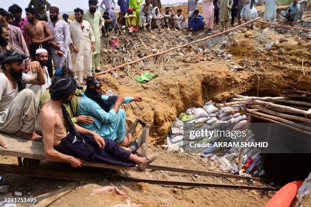 Miners sitting on a lift prepare to recover the bodies of miners who died after a flash flood following torrential rains inundated a coal mine, in...