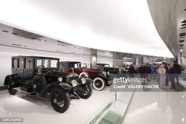 Visitors stand by cars during the inauguration of the new museum housing the Prince of Monaco's private car collection, in Monaco on July 7, 2022.