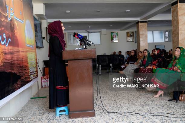 An Afghan woman reads during an annual poetry gathering held in the capital, their first since the Taliban came to power and stripped women of their...