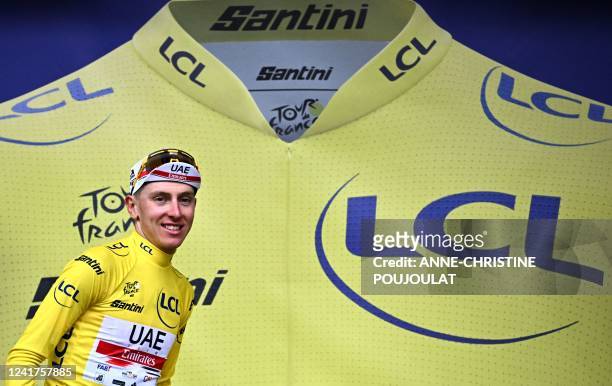 Team Emirates team's Slovenian rider Tadej Pogacar wearing the overall leader's yellow jersey celebrates on the podium after the 6th stage of the...