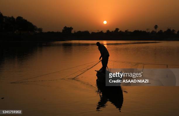 Fisherman pulls his net on the Euphrates river at sunset in the Iraqi city of Nasiriyah in the Dhi Qar province, about 360 kms southeast of the...