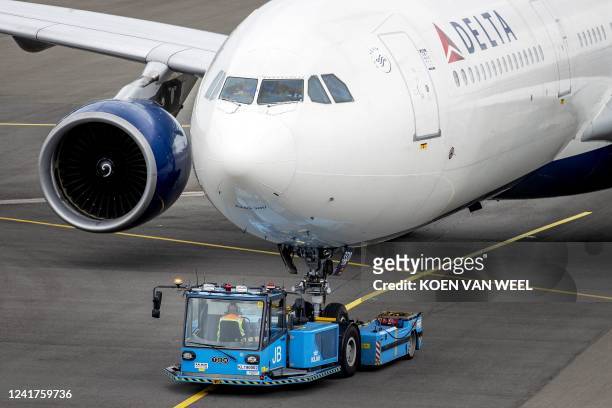 Pushback tractor moves a Delta Airlines plane on July 7, 2022 at Amsterdam's Schiphol Airport which, faced with staff shortages, was forced to...