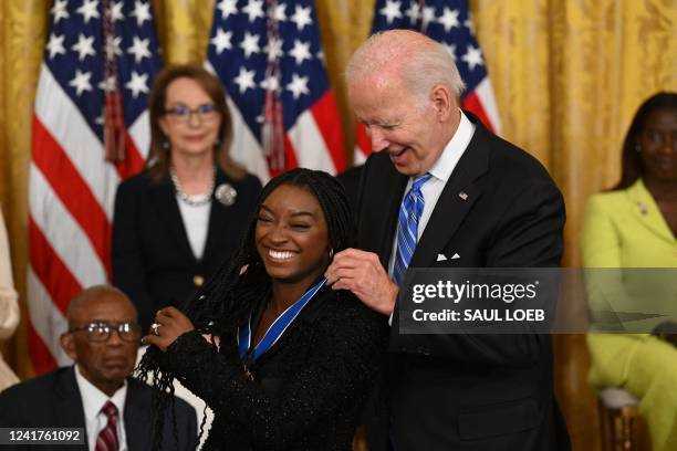 President Joe Biden presents gymnast Simone Biles with the Presidential Medal of Freedom, the nation's highest civilian honor, during a ceremony...