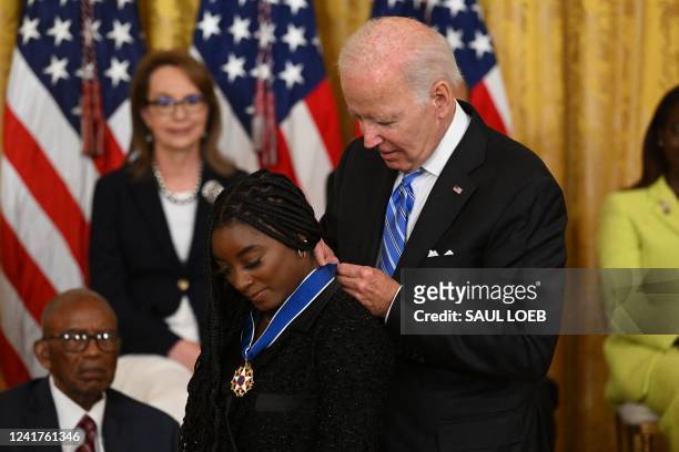 President Joe Biden presents gymnast Simone Biles with the Presidential Medal of Freedom, the nation's highest civilian honor, during a ceremony...