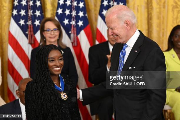 President Joe Biden presents gymnast Simone Biles with the Presidential Medal of Freedom, the nation's highest civilian honor, during a ceremony...