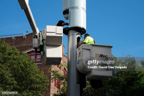 Workers install a Link5G-transmitting smart pole which sits atop of a LinkNYC kiosk on July 7, 2022 in The Bronx borough of New York City. The...