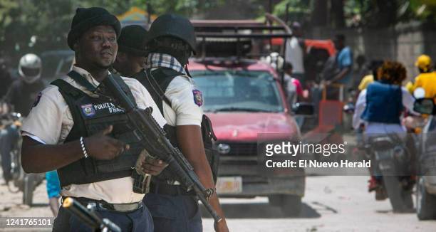 Haitian National Police officer looks out over traffic at a police checkpoint on the outskirts of metropolitan Port-au-Prince on June 23, 2022....