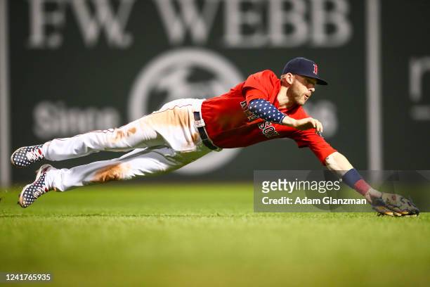 Trevor Story of the Boston Red Sox dives for a ground ball in the eighth inning of a game against the New York Yankees at Fenway Park on July 7, 2022...