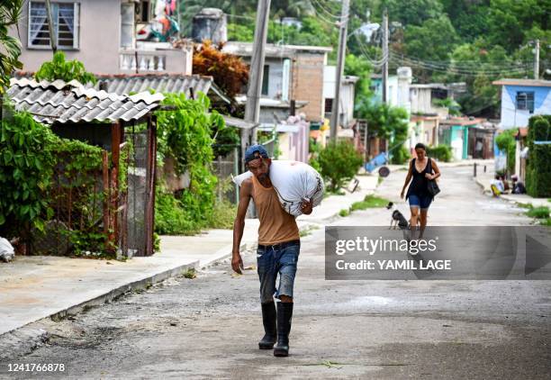 Man walks along a street in La Guinera neighbourhood, on the outskirts of Havana, on June 30, 2022. - As Cuba marks the first anniversary of the...