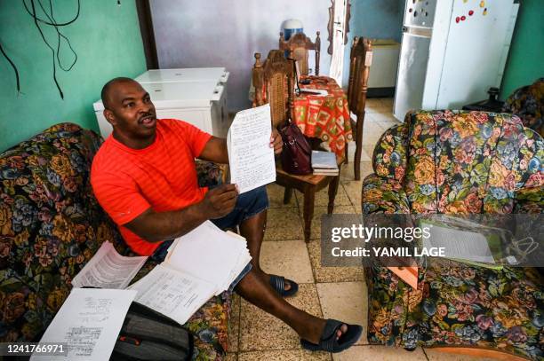 Luis Wilber Aguilar, father of Wagniel Aguilar, who was prosecuted for the July 11-12 anti-government protests, shows medical documents of his son at...