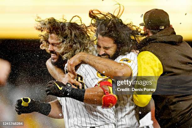 Jorge Alfaro of the San Diego Padres, left, celebrates with teammates after hitting a walk-off single during the tenth inning of a baseball game...