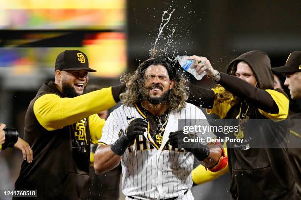 Jorge Alfaro of the San Diego Padres, center, celebrates with teammates after hitting a walk-off single during the tenth inning of a baseball game...