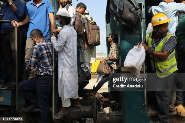 Home-bound people crowd onto the roof of a train as they take a risk as they attempt to travel to their villages, ahead of the Eid-Al-Adha...