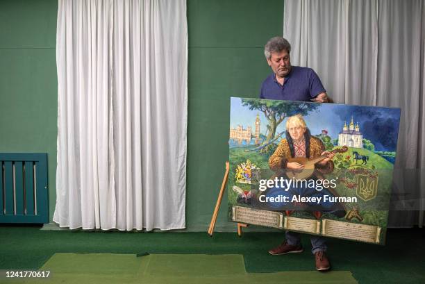 Serhii Layevskyi, director of Chernihiv Historical Museum, carries the painting of Boris Johnson dressed as a Ukrainian cossack by Ukrainian artists...