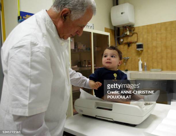 Un enfant de 18 mois est pesé par un pédiatre, le 08 janvier 2005 pendant une consultation gratuite dans un centre médical à Marseille, lors de la...
