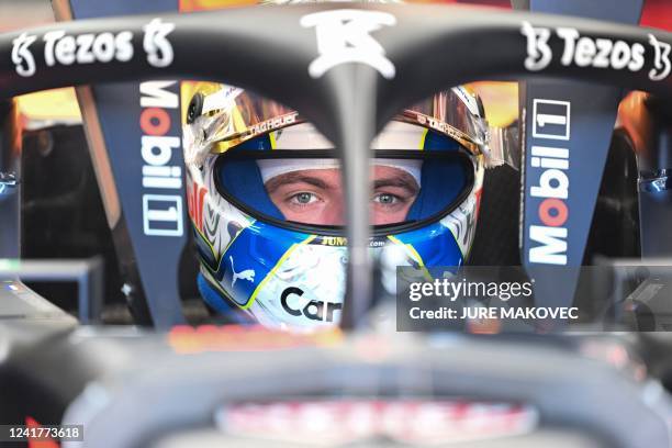 Red Bull Racing's Dutch driver Max Verstappen is seen behind the halo as he sits in his car in the pits prior to the first practice session at the...