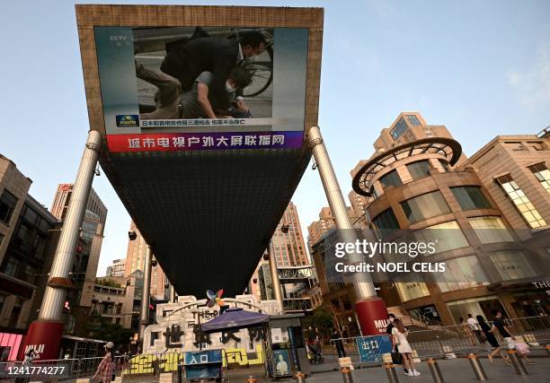 Large video screen shows news broadcast of the gunman that killed former Japanese prime minister Shinzo Abe in Beijing on July 8, 2022. - Abe was...