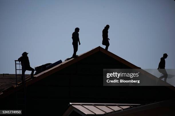 Contractors stand on the roof of a house under construction at the Norton Commons subdivision in Louisville, Kentucky, US, on Friday, July 1, 2022....