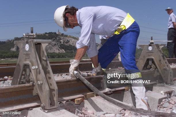 Un employé du réseau ferré achève le meulage de la première soudure du TGV Méditerranée Valence-Nîmes-Marseille, le 03 juin 1999 à Cheval Blanc,...