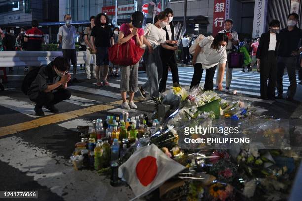 People pay their respects in front of a makeshift memorial outside Yamato-Saidaiji Station, where former Japanese prime minister Shinzo Abe was shot...