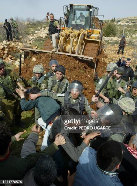 Israeli border police clash with residents of the West Bank town of Beit Surik as they try to prevent Israeli bulldozers to start working in a new...