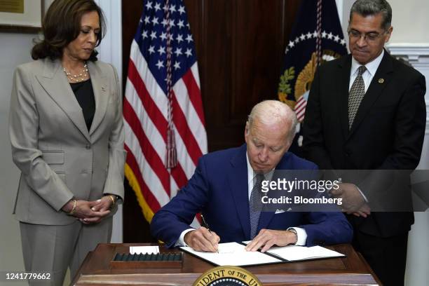 President Joe Biden signs an executive order with US Vice President Kamala Harris, left, and Xavier Becerra, secretary of Health and Human Services ,...